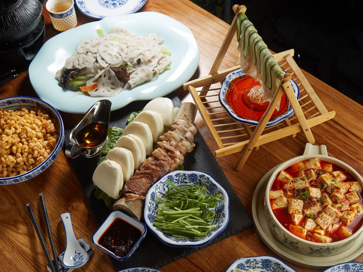 A selection of Sichuan dishes, including thinly sliced cucumber, mapo tofu, and lotus root