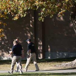 Police walk around the campus of Union Middle School after a shooting involving two juveniles took place outside the Sandy school on Tuesday, Oct. 25, 2016.