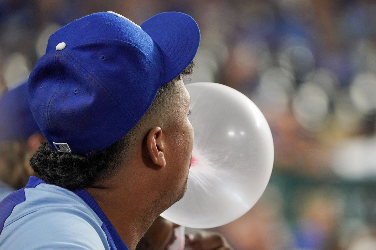 Kansas City Royals relief pitcher Carlos Hernandez (43) blows a large bubble while watching from the dugout against the Seattle Mariners in the ninth inning at Kauffman Stadium. 