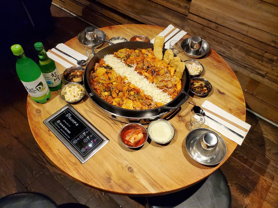 A cast iron pan filled with chicken and cheese on a round table