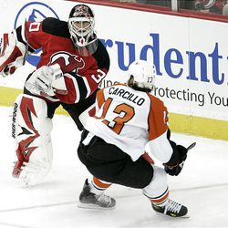 New Jersey Devils goalie Martin Brodeur (30) keeps his eye on the puck as Philadelphia Flyers' Dan Carcillo (13) closes in during the second period.