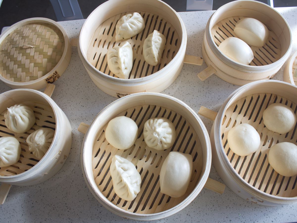 Assorted pieces of bao in several steamer baskets.
