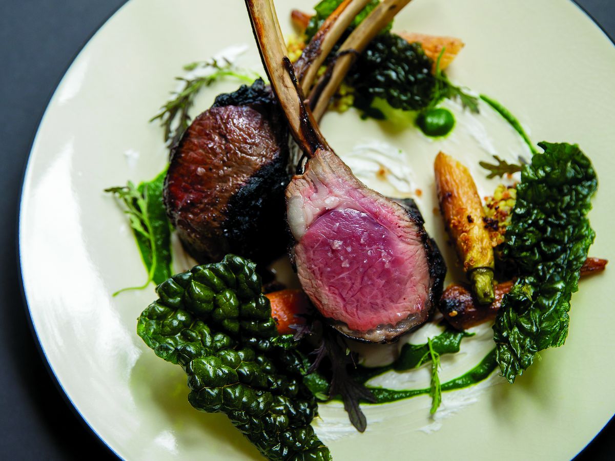Two lamb chops on a plate with swirls of greens.