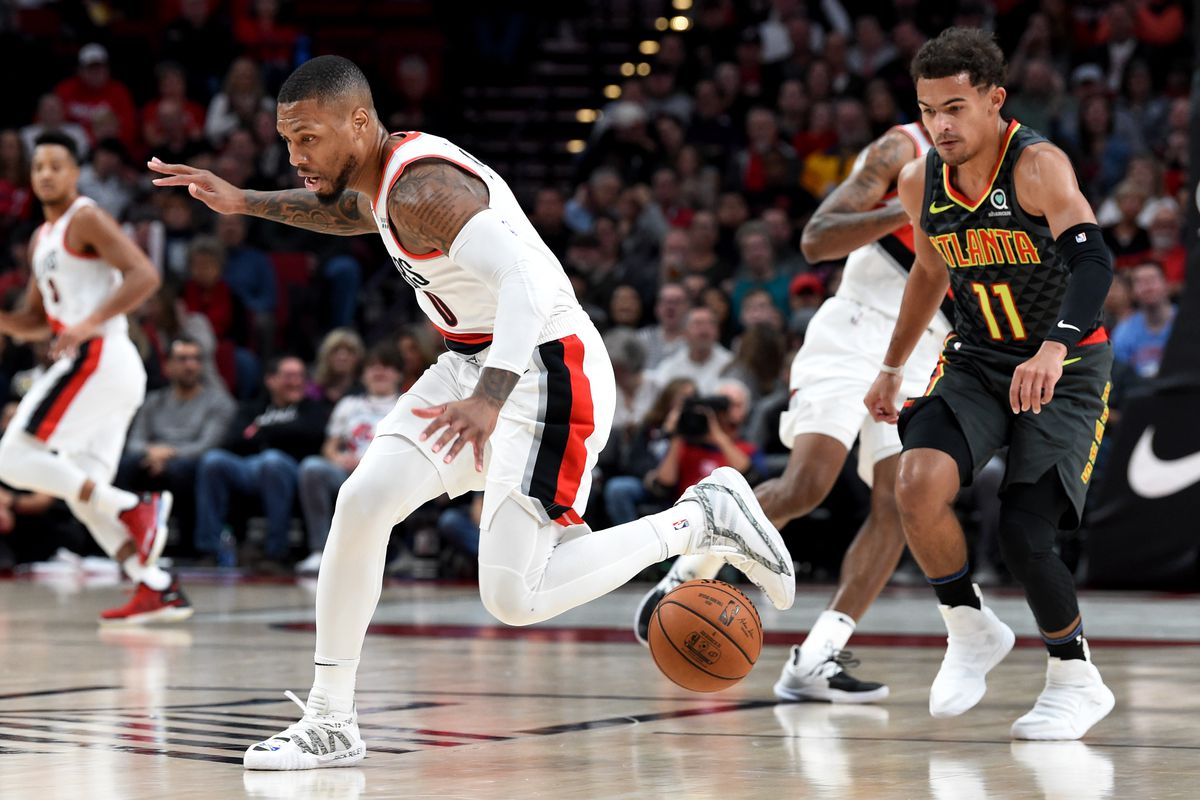 Portland Trail Blazers guard Damian Lillard loses control of the ball as Atlanta Hawks guard Trae Young closes in during the first half of the game at Moda Center.
