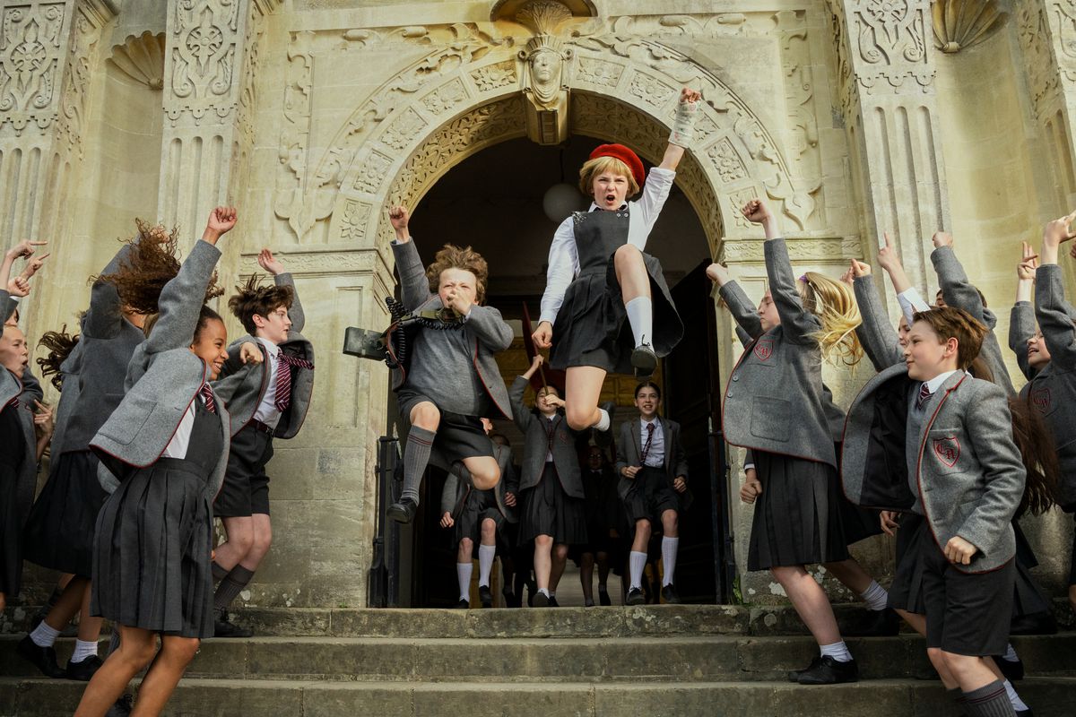 The children in Matilda the Musical jump and cheer on their way out of the school building.