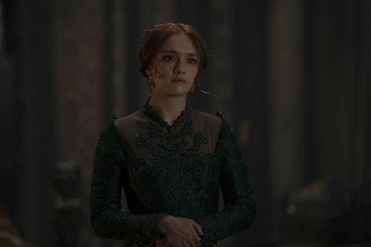 Olivia Cooke, wearing green, clasps her hands together in House of the Dragon.