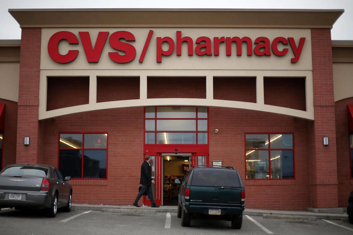 In this March 17, 2014 photo, a man walks in front of a CVS/Pharmacy in Dormont, Pa. CVS reports quarterly financial results on Tuesday, Feb. 10, 2015.  