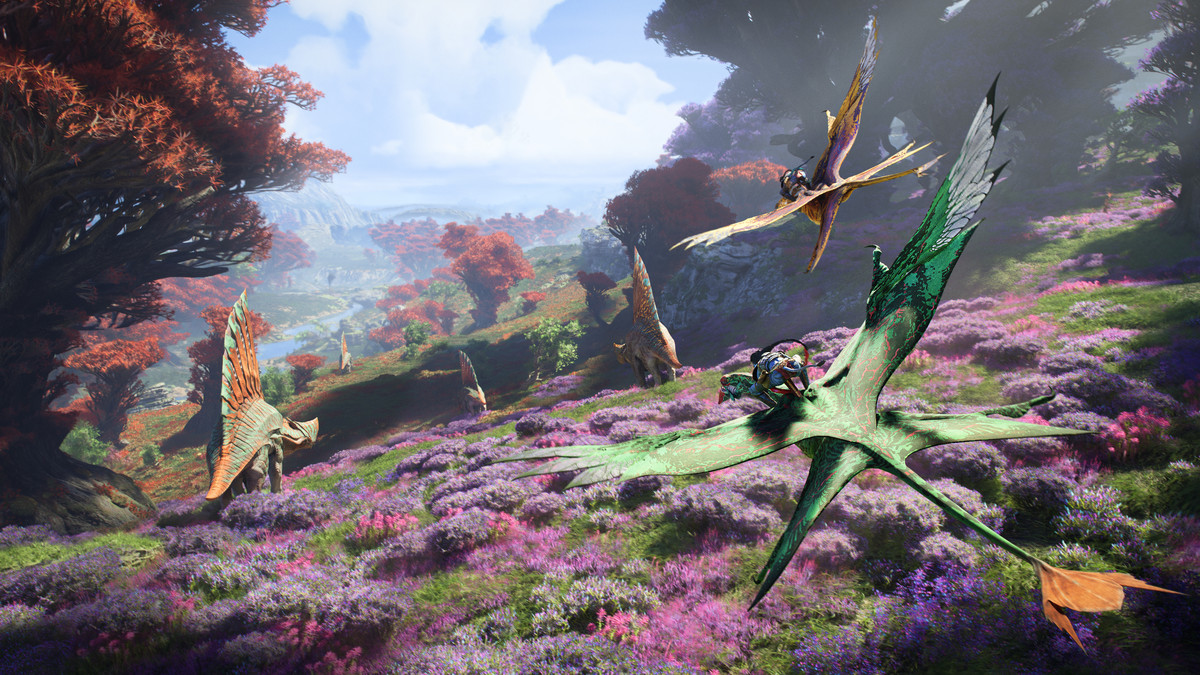 Two Na’vi soar above Pandora, where a field full of pink flowers and dinosaur-like creatures unfolds below, in Avatar: Frontiers of Pandora
