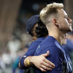 Eugenio Suarez #28 of the Seattle Mariners puts his arm around Jarred Kelenic #10 during the seventh inning