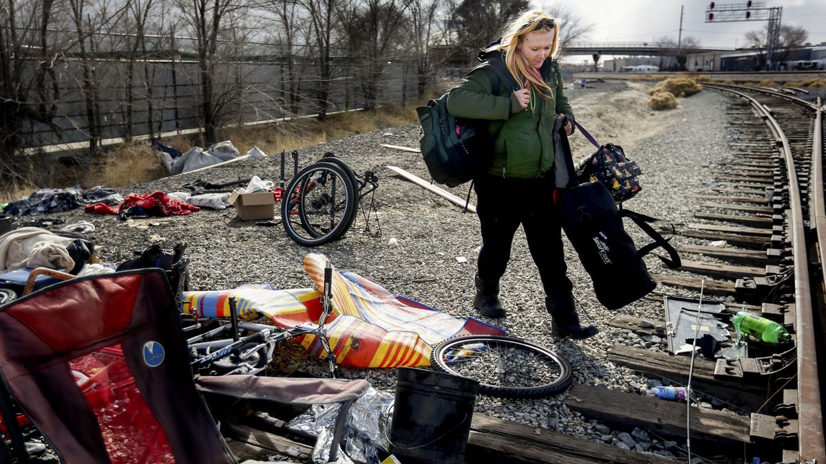 Kelsey Wright grabs some of her belongings from her encampment on Union Pacific property in Salt Lake City on Thursday, Feb. 4, 2021. Kelsey and her boyfriend grabbed as much as they could before a backhoe arrived to haul everything away.