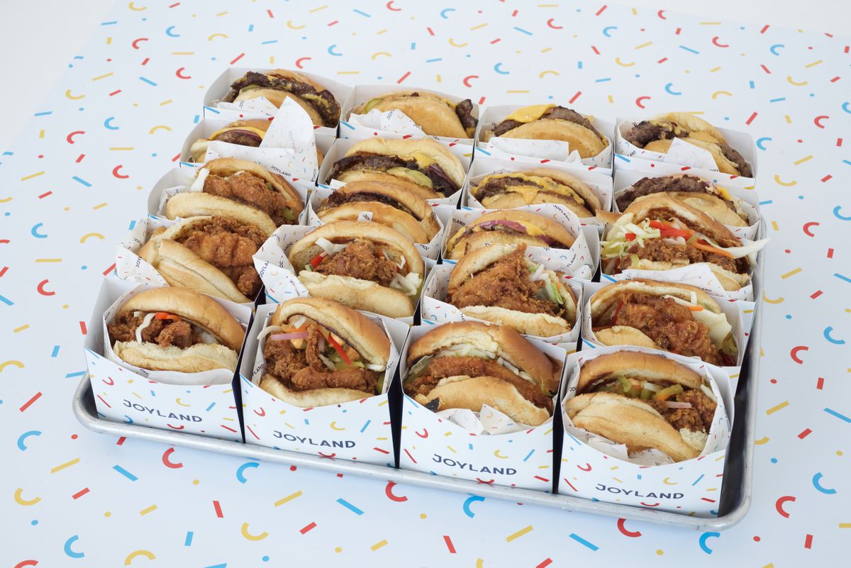 a tray full of assorted burgers and chicken sandwiches