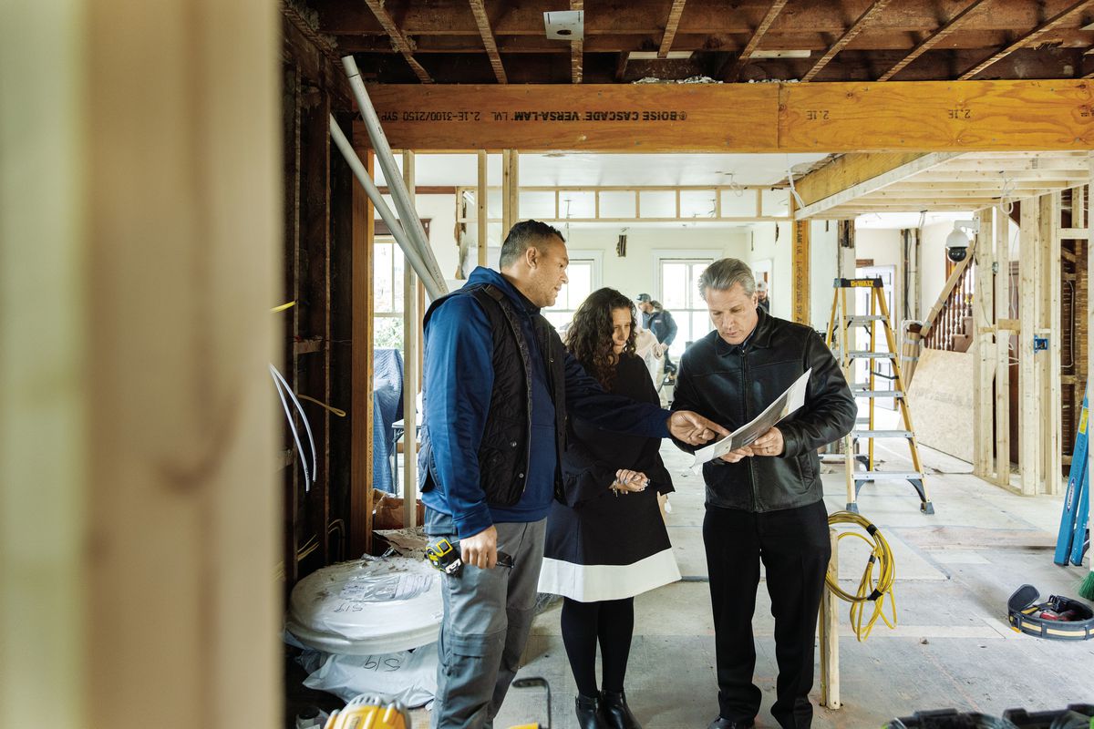 General contractor Deliandro Dias (left) reviews the kitchen layout with homeowners Robyn Marder and Derek Rubinoff, who is also the project’s architect. New LVL beams provide the strength needed to open up the floor plan.
