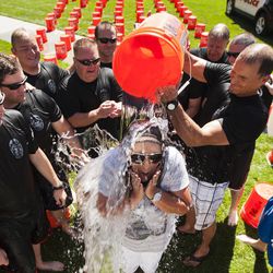 Draper Police Chief Bryan Roberts, right, dumps a bucket of ice water on Shante Johnson, wife of Sgt. Derek Johnson who was killed in the line of duty last year, during the the Utah Law Enforcement Memorial Ice Water Challenge at Draper Historic Park, Wednesday, Sept. 3, 2014. One bucket of ice water was dumped on an officer's head for each of the 137 officers who have been killed in the line of duty in Utah.