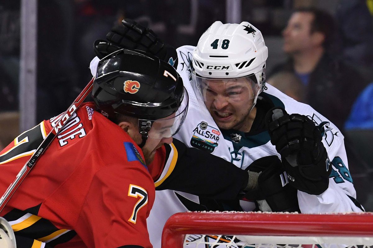 Dec 31, 2018; Calgary, Alberta, CAN; Calgary Flames defenseman T.J. Brodie (7) tangles with San Jose Sharks center Tomas Hertl (48) during the second period at Scotiabank Saddledome.