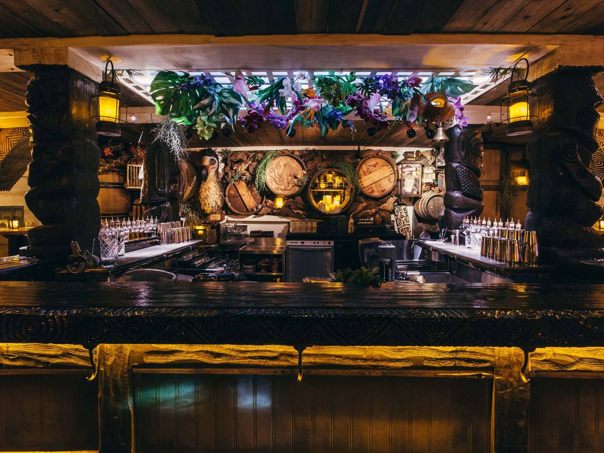 The bar at Undertow, with plants hanging from the ceiling and barrel designs in the background.