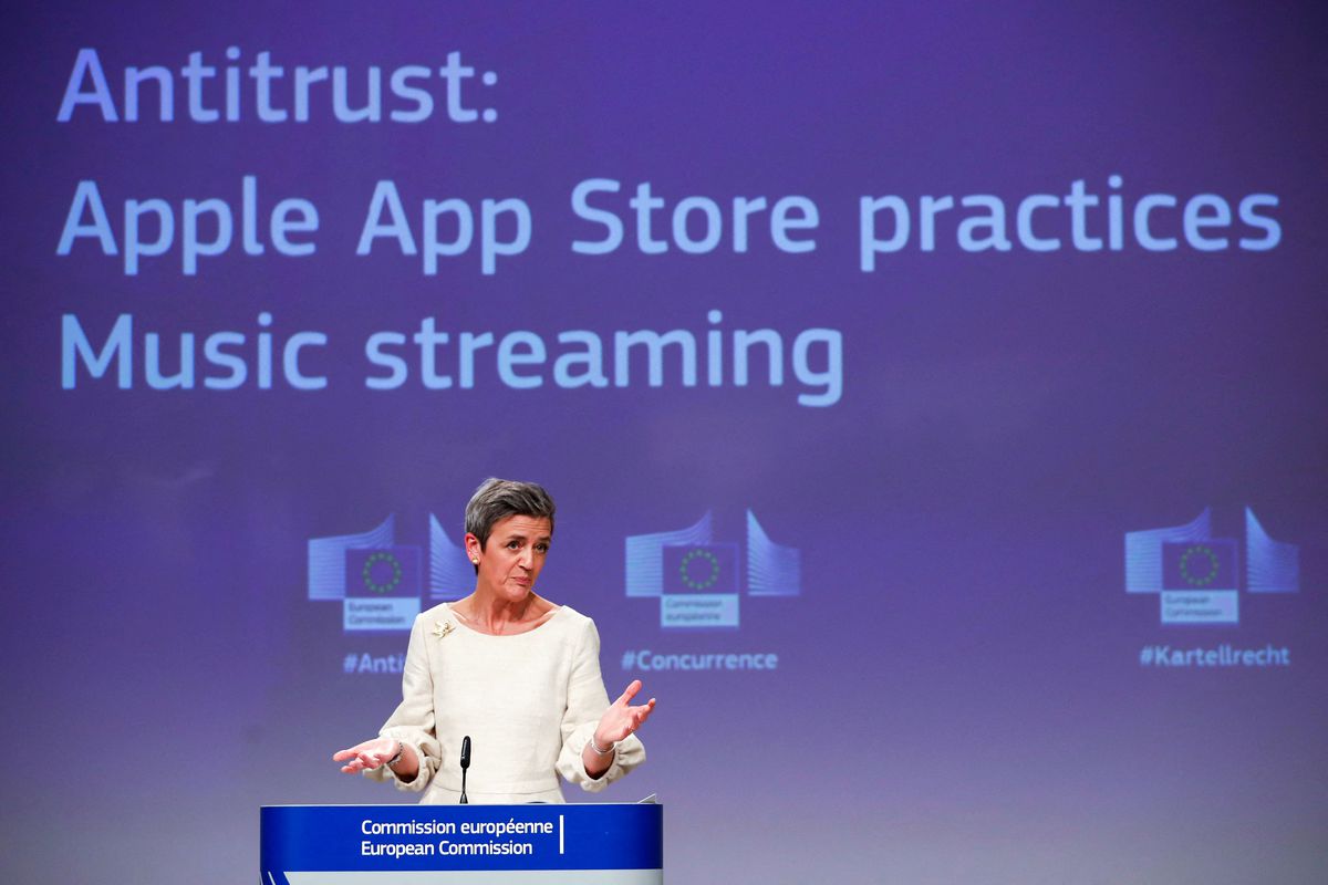 Margrethe Vestager speaking onstage in front of a wall that reads, “Antitrust: Apple App Store practices Music streaming.”