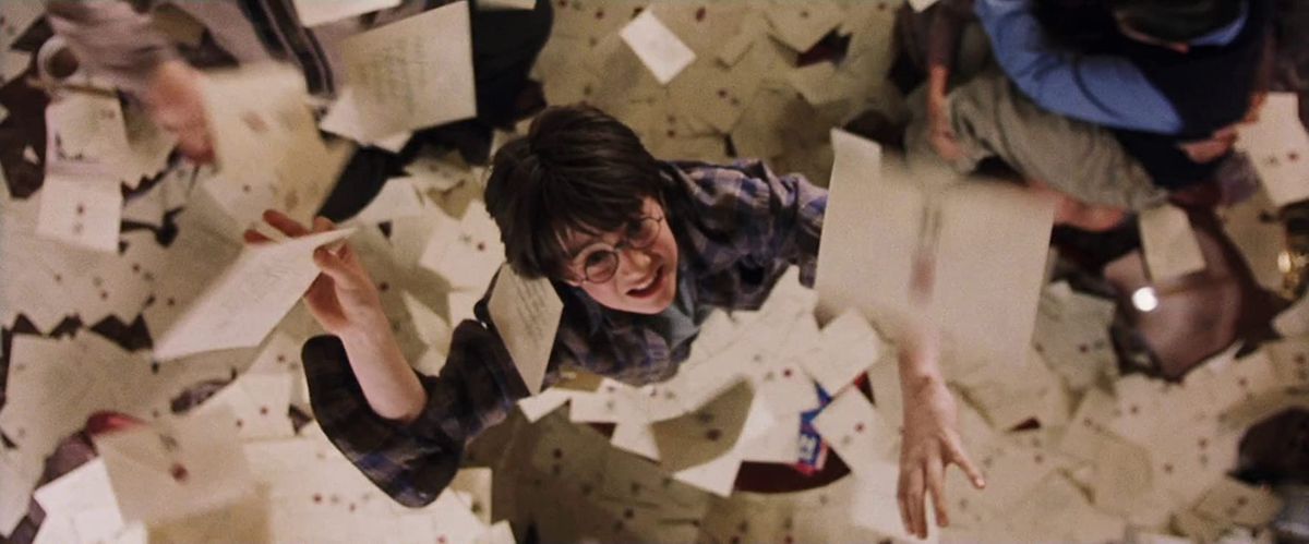 Harry (Daniel Radcliffe) grabs at letters falling from the ceiling