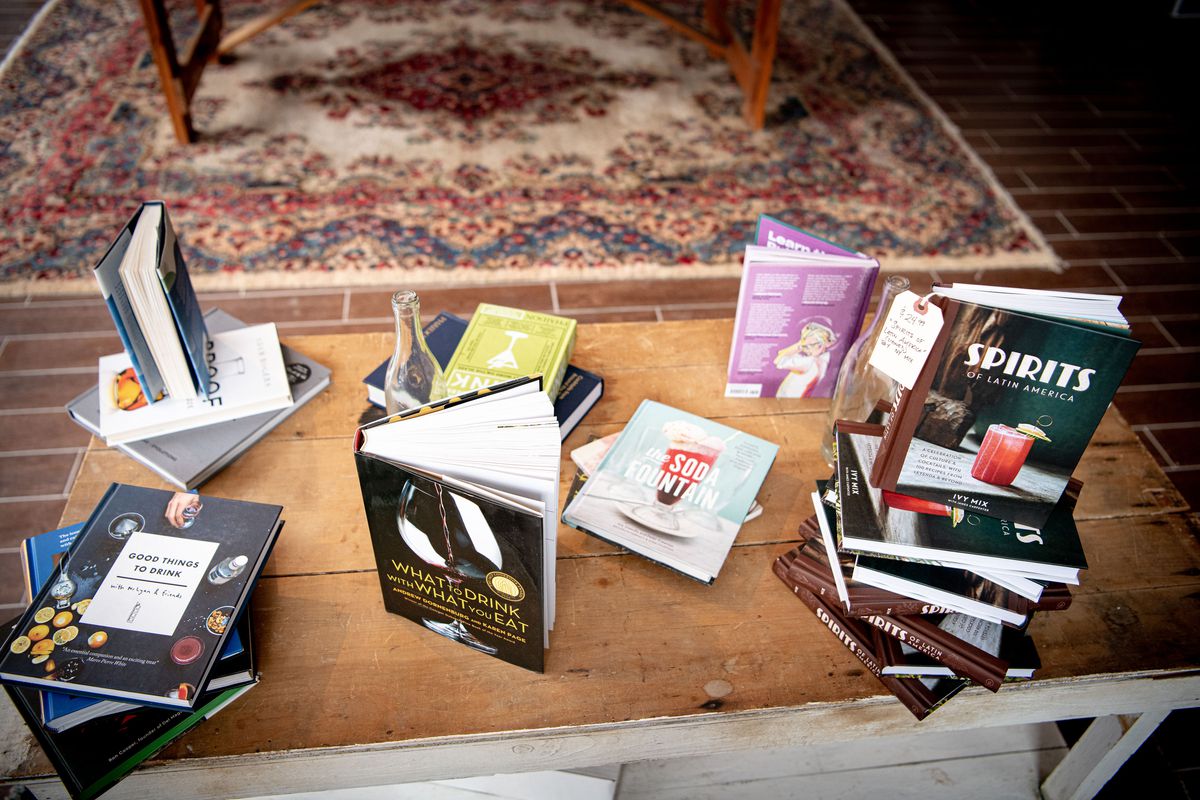 Several books are placed on a wooden table