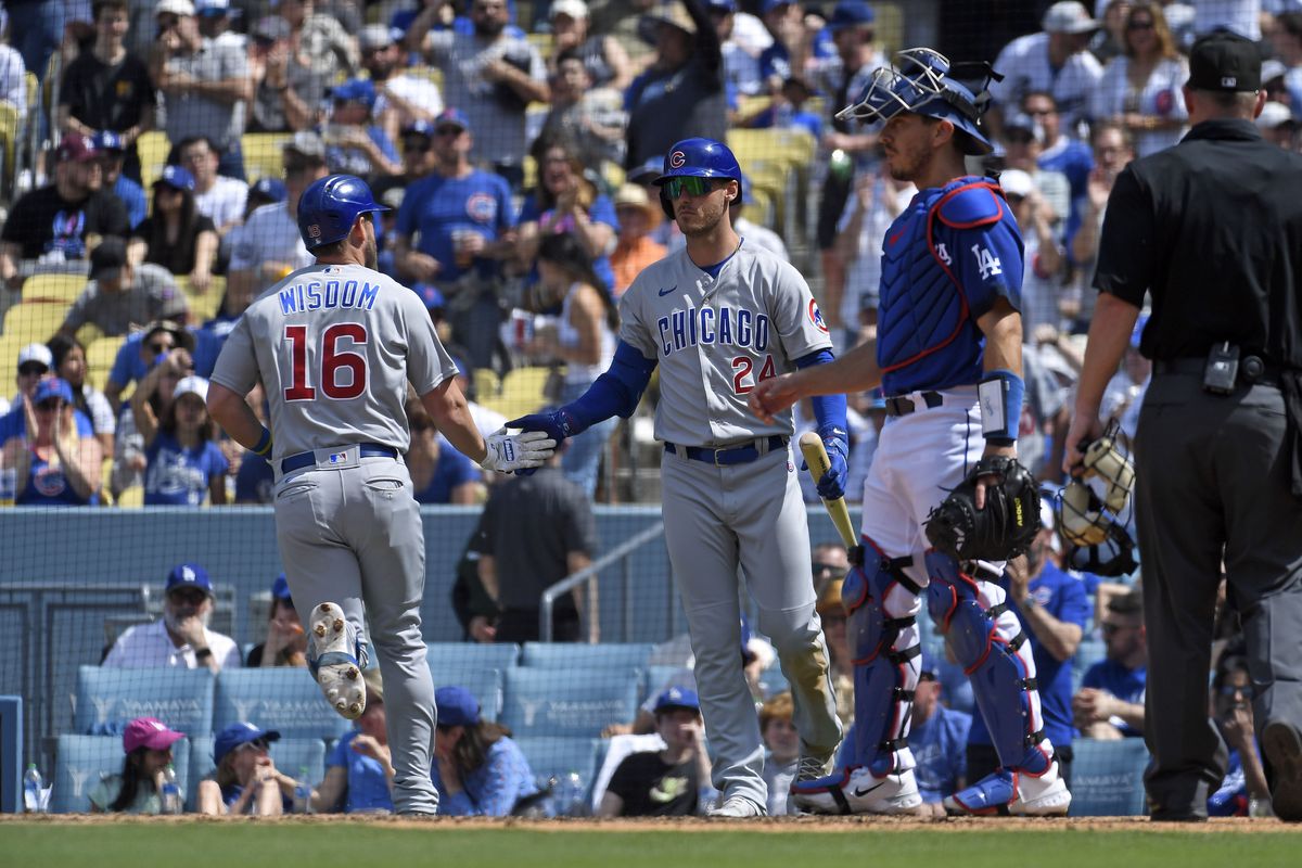 Cody Bellinger of the Chicago Cubs congratulates Patrick Wisdom #16 after hitting a one run home run against starting pitcher Julio Urias #7 of the Los Angeles Dodgers during the sixth inning at Dodger Stadium on April 16, 2023 in Los Angeles, California.
