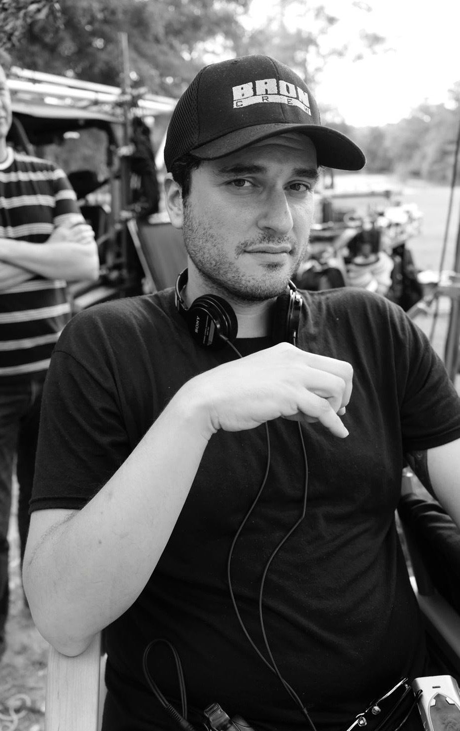 a black-and-white photo of Josh Trank on the set of Capone