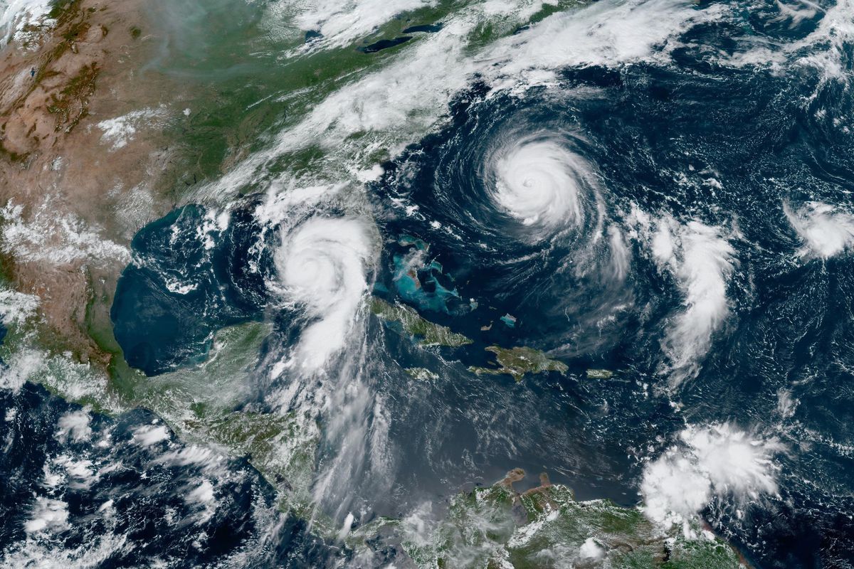 An overhead satellite map showing hurricanes swirling in the ocean off Florida.