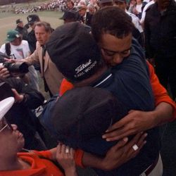 Tiger Woods hugs his father Earl after winning the 1997 Masters with a record-breaking 18-under-par at Augusta National Golf Club in Augusta, Ga., Sunday, April 13, 1997. Tiger's mother, Kultida looks on.