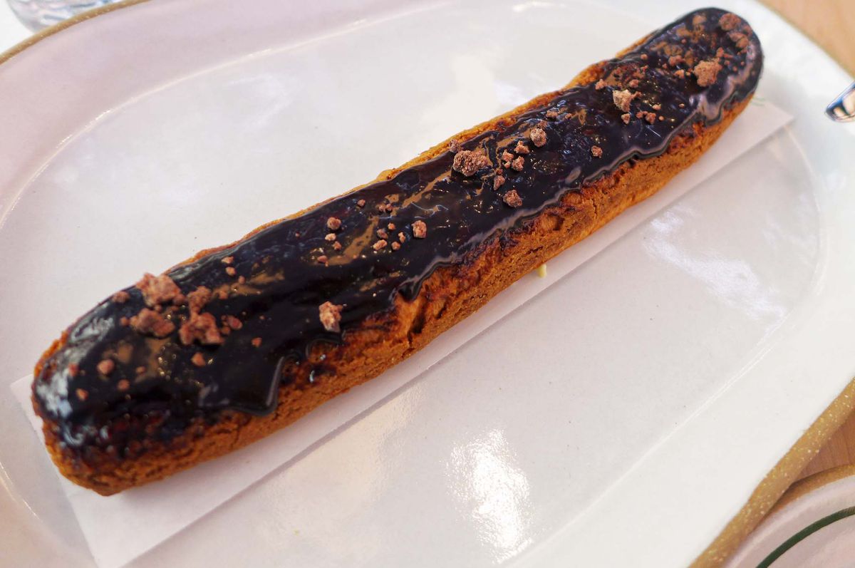 A long pastry smothered in chocolate sauce.