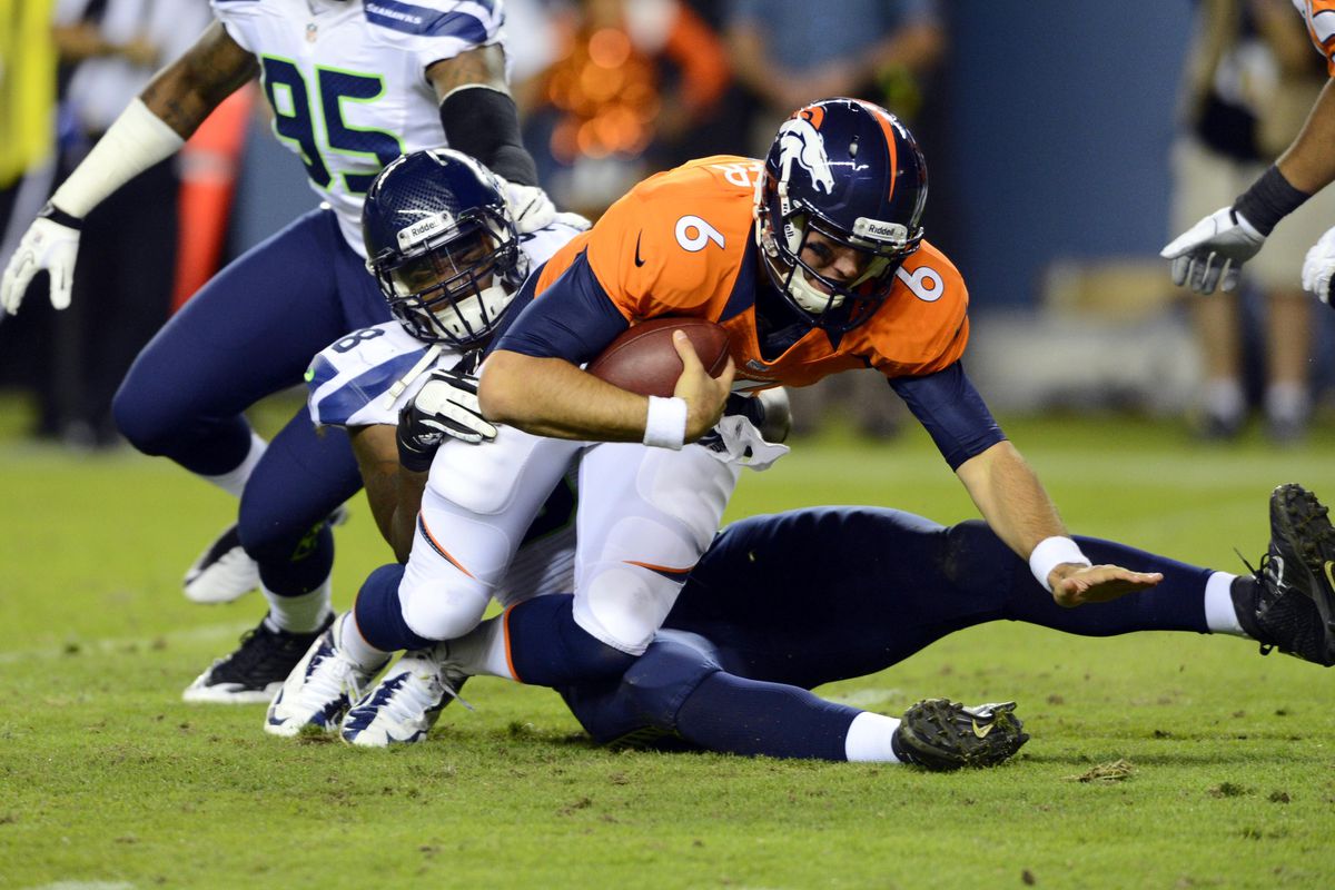 August 18 2012; Denver, CO, USA; Denver Broncos quarterback Brock Osweiler (6) is sacked by Seattle Seahawks defensive end Greg Scruggs (98) in the third quarter of a preseason game at Sports Authority Field. Mandatory Credit: Ron Chenoy-US PRESSWIRE