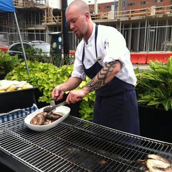 Chef Kyle Bailey at the grill cooking up barbecue porchetta.