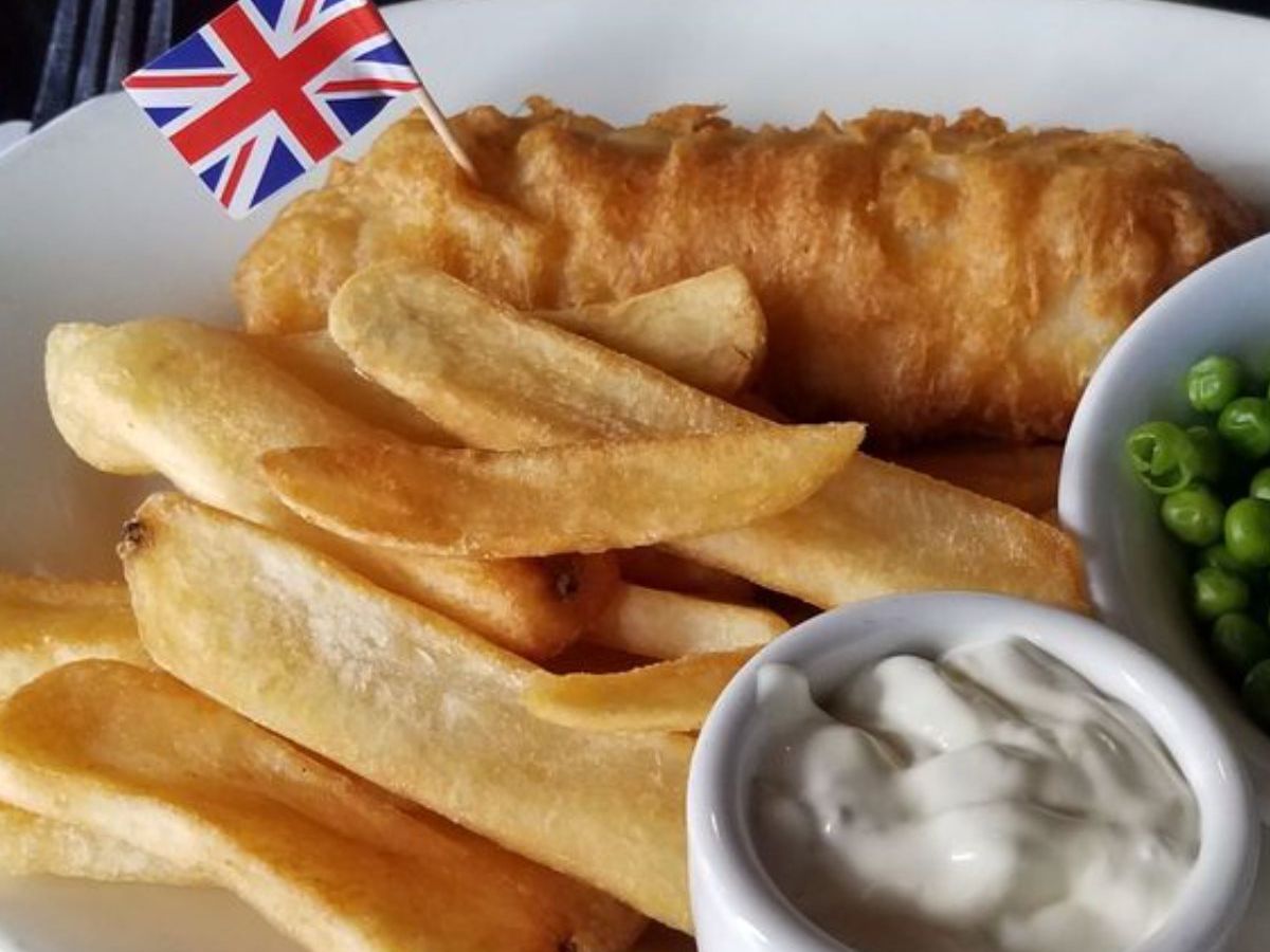 A white plate with fish and chips