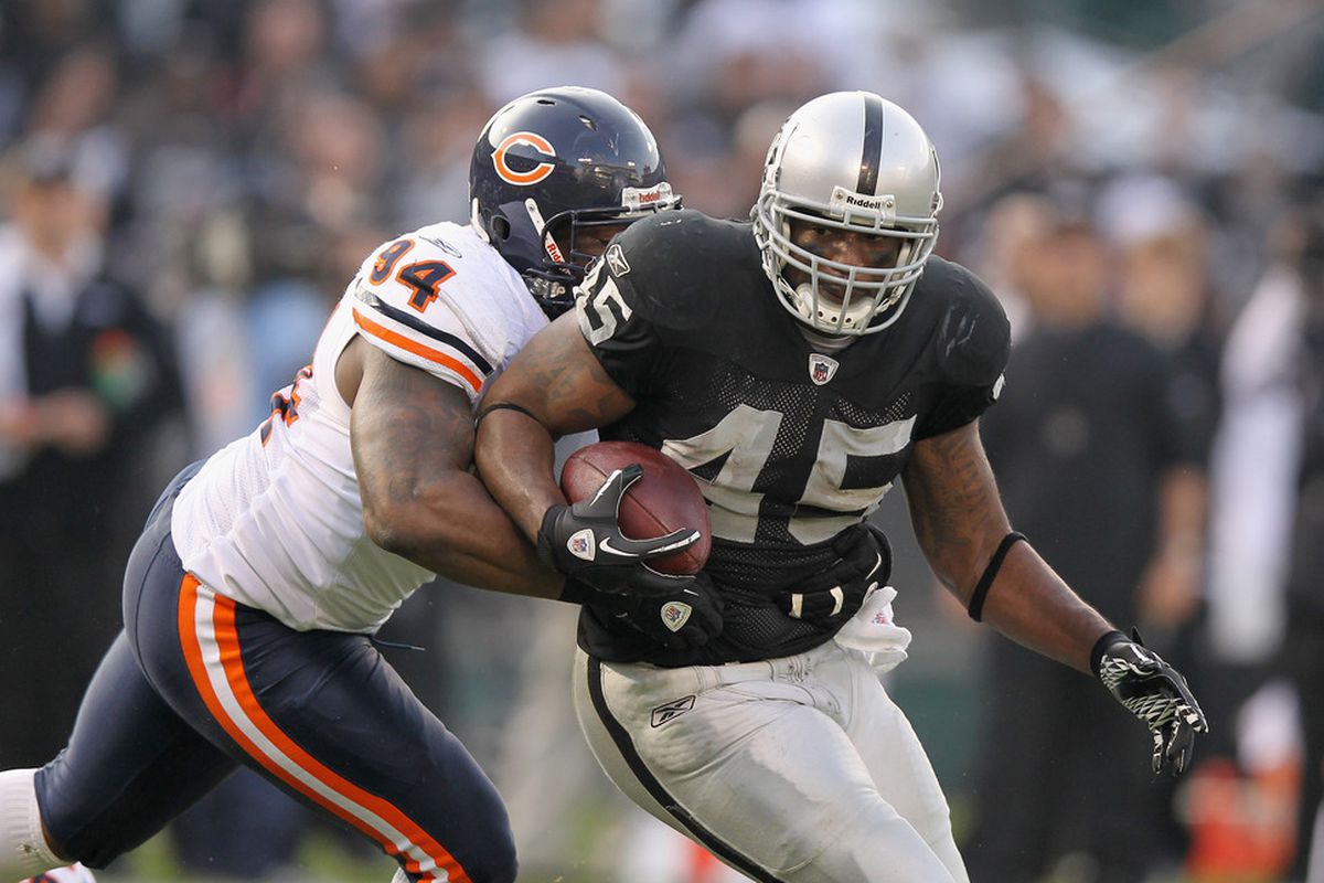 Marcel Reece #45 of the Oakland Raiders is tackled by Chauncey Davis #94 of the Chicago Bears at O.co Coliseum on November 27, 2011
