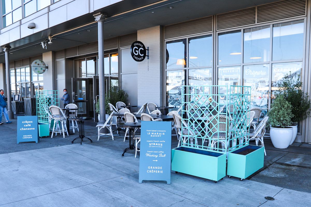 The patio at Grande Creperie with turquoise planters and tables.