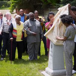 A group of people unveil the new headstone for Hark Lay Wales, who was laid to rest in the Union Pioneer Cemetery in Cottonwood Heights, Utah, in 1887. Before Monday, May 27, 2019, his grave had been without a headstone or identification.