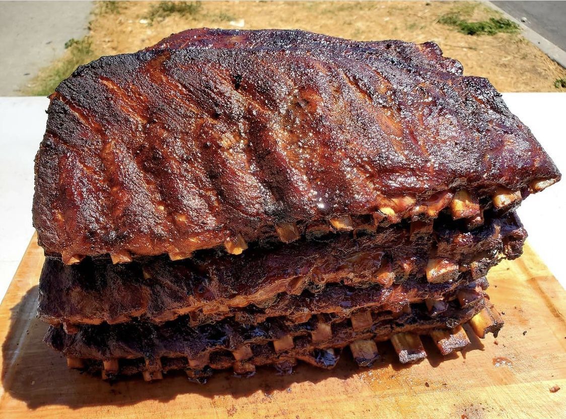 A stack of deep red ribs with char at the edges.
