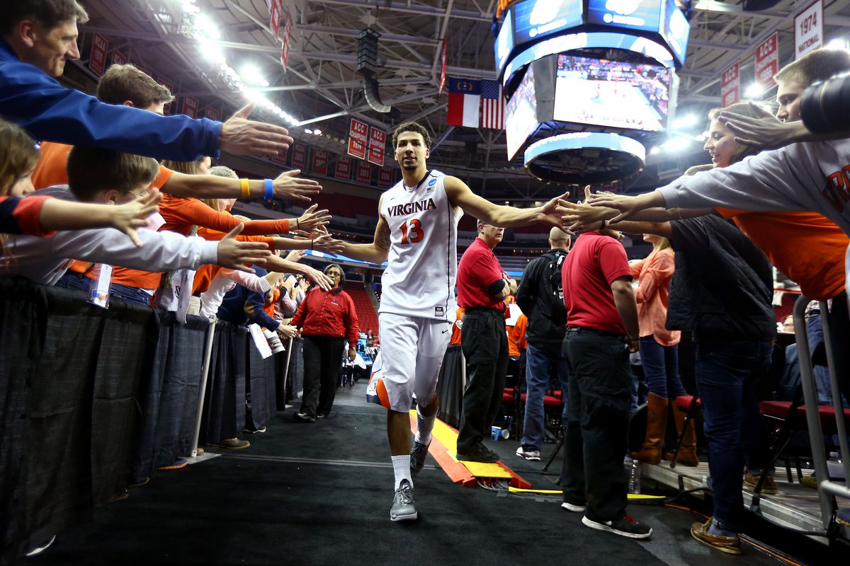 RALEIGH, NC - MARCH 23: Anthony Gill #13 of the Virginia Cavaliers celebrates with fans while exiting the court after defeating the Memphis Tigers during the third round of the 2014 NCAA Men's Basketball Tournament at PNC Arena on March 23, 2014 in R