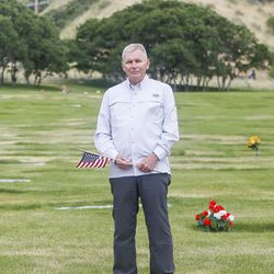 Ken Evans poses for a portrait by his father's grave at the Orem Cemetery on Monday, June 12, 2017.