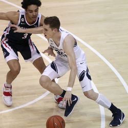 Brigham Young Cougars guard Spencer Johnson (20) dribbles around Gonzaga Bulldogs guard Andrew Nembhard (3) during a basketball game at the Marriott Center in Provo on Monday, Feb. 8, 2021. BYU lost 71-82.