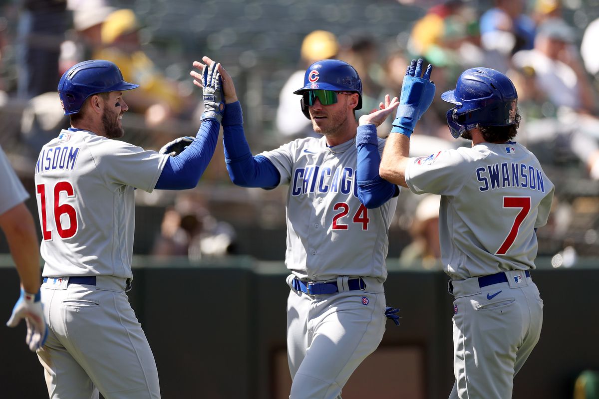 Cody Bellinger of the Chicago Cubs is congratulated by Patrick Wisdom and Dansby Swanson after he scored in the ninth inning against the Oakland Athletics at RingCentral Coliseum on April 19, 2023 in Oakland, California.