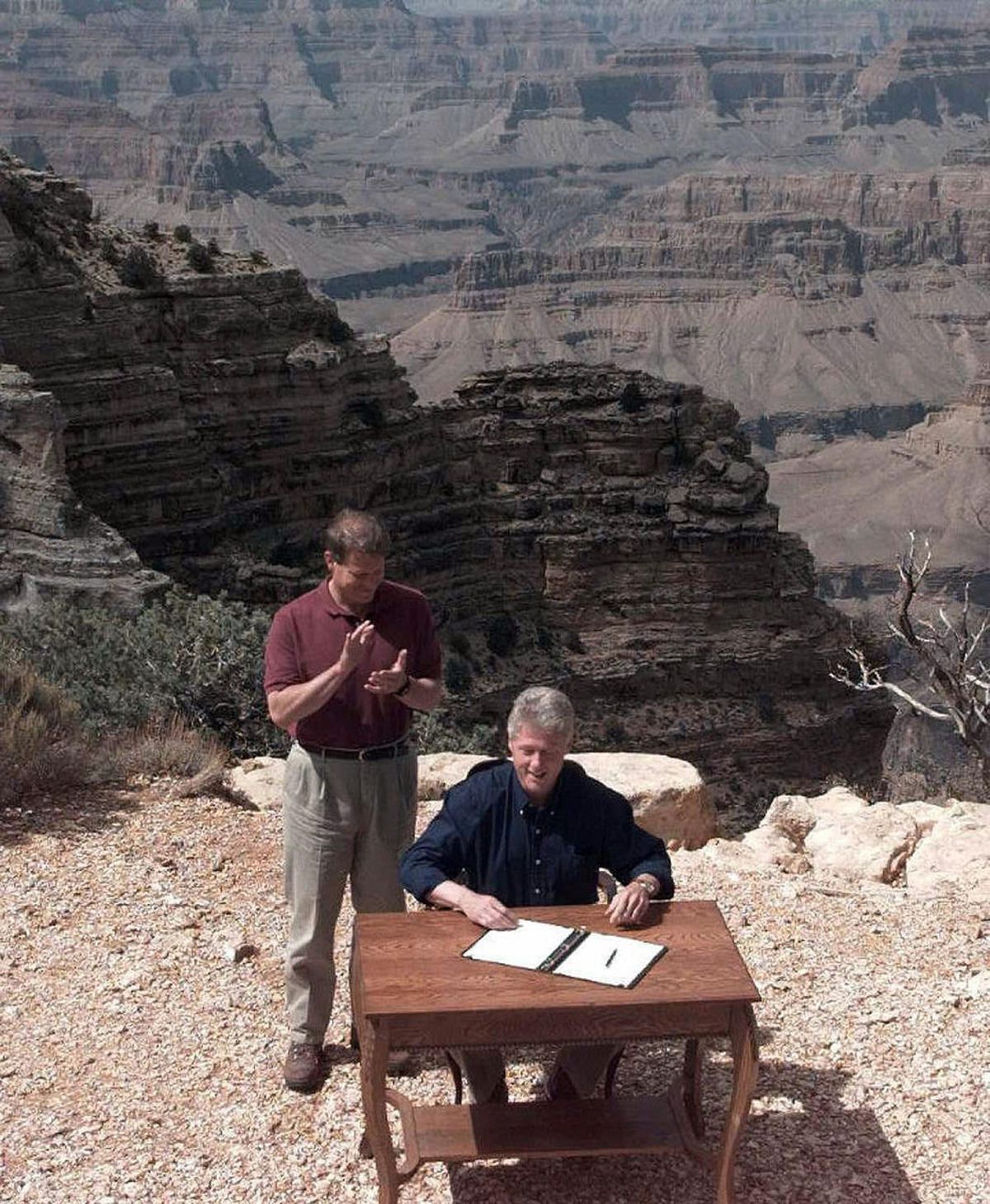 President Bill Clinton signs an order in Grand Canyon National Park in Arizona to designate a vast canyonland in Utah, including Grand Escalante Staircase, a national monument Sept. 18, 1996, while Vice President Al Gore watches.