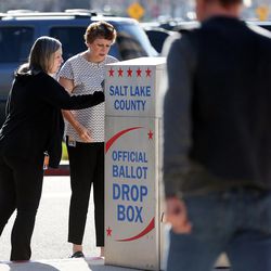 Camille Crist, left, and Jeannie Childs place their ballots in a drop box at the Salt Lake County Government Center in Salt Lake City on Monday, Nov. 7, 2016.