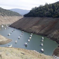 In this Thursday, Oct. 30, 2014 file photo, houseboats sit in the drought lowered waters of Oroville Lake, near Oroville, Calif. State officials reported Tuesday, Feb. 3, 2015, that residents in drought-stricken California met Gov. Jerry Brown's call to slash water use by 20 percent for the first time in December, when water use fell by 22 percent compared to the same month in 2013.