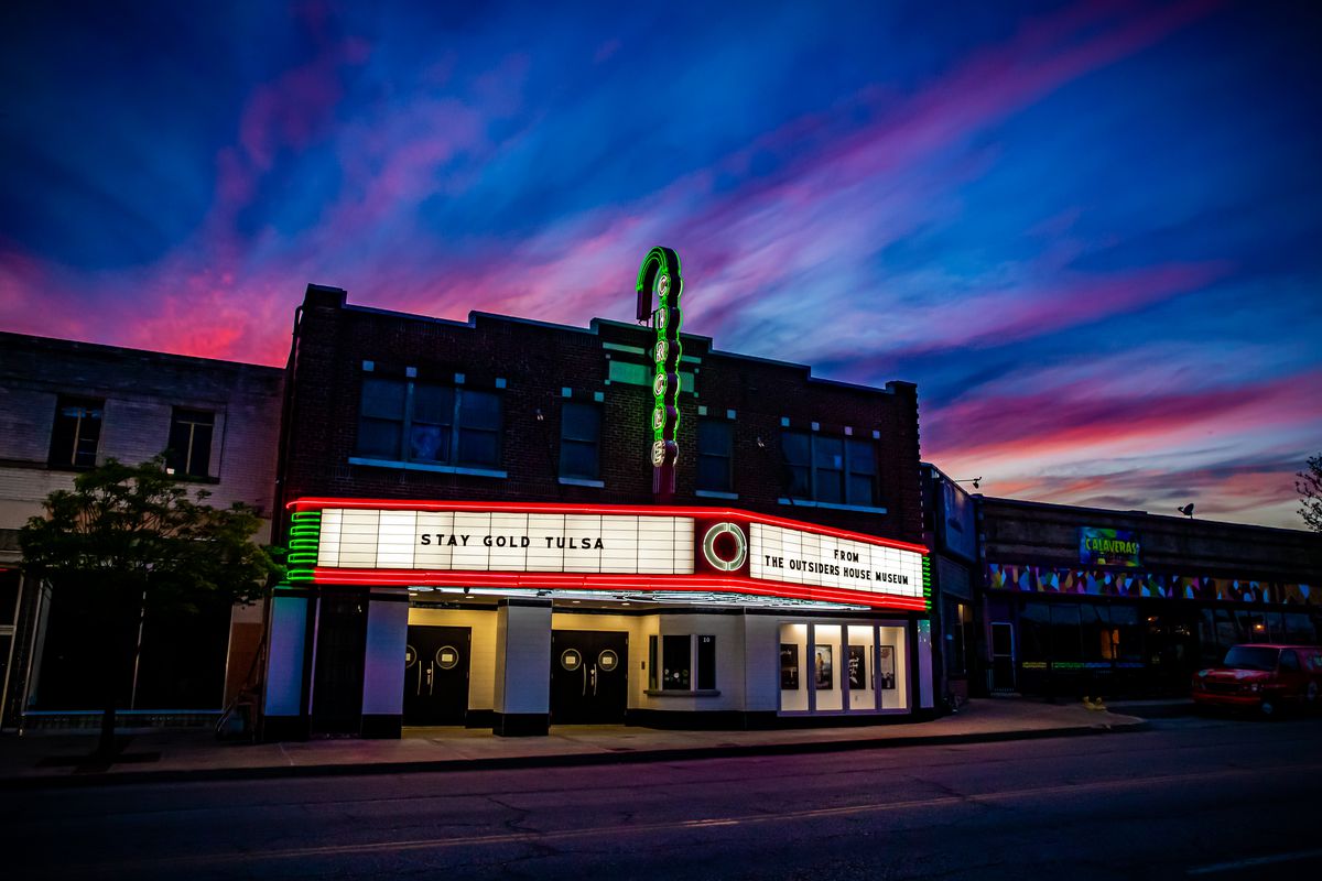 A small movie theater at dusk with the words, “Stay gold, Tulsa,” on the marquee.