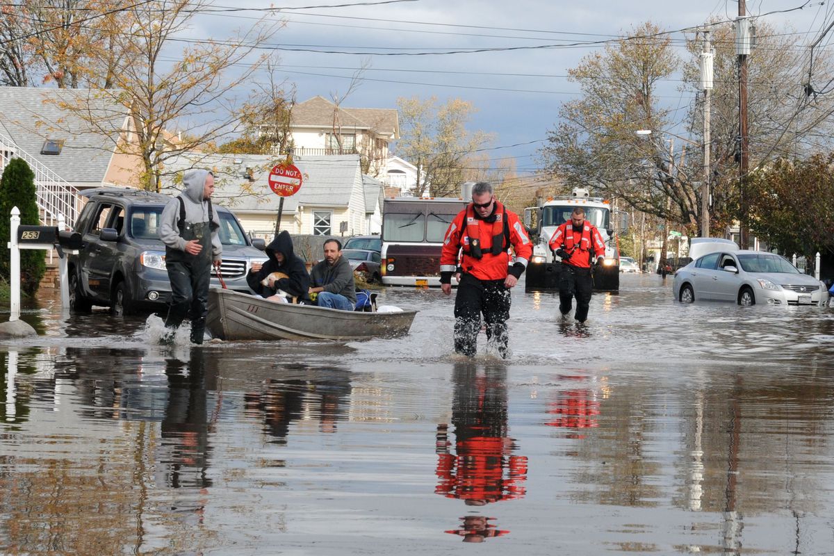 Emergency workers help people evacuate their flooded homes in Midland Beach, Staten Island, after Superstorm Sandy in fall 2012.
