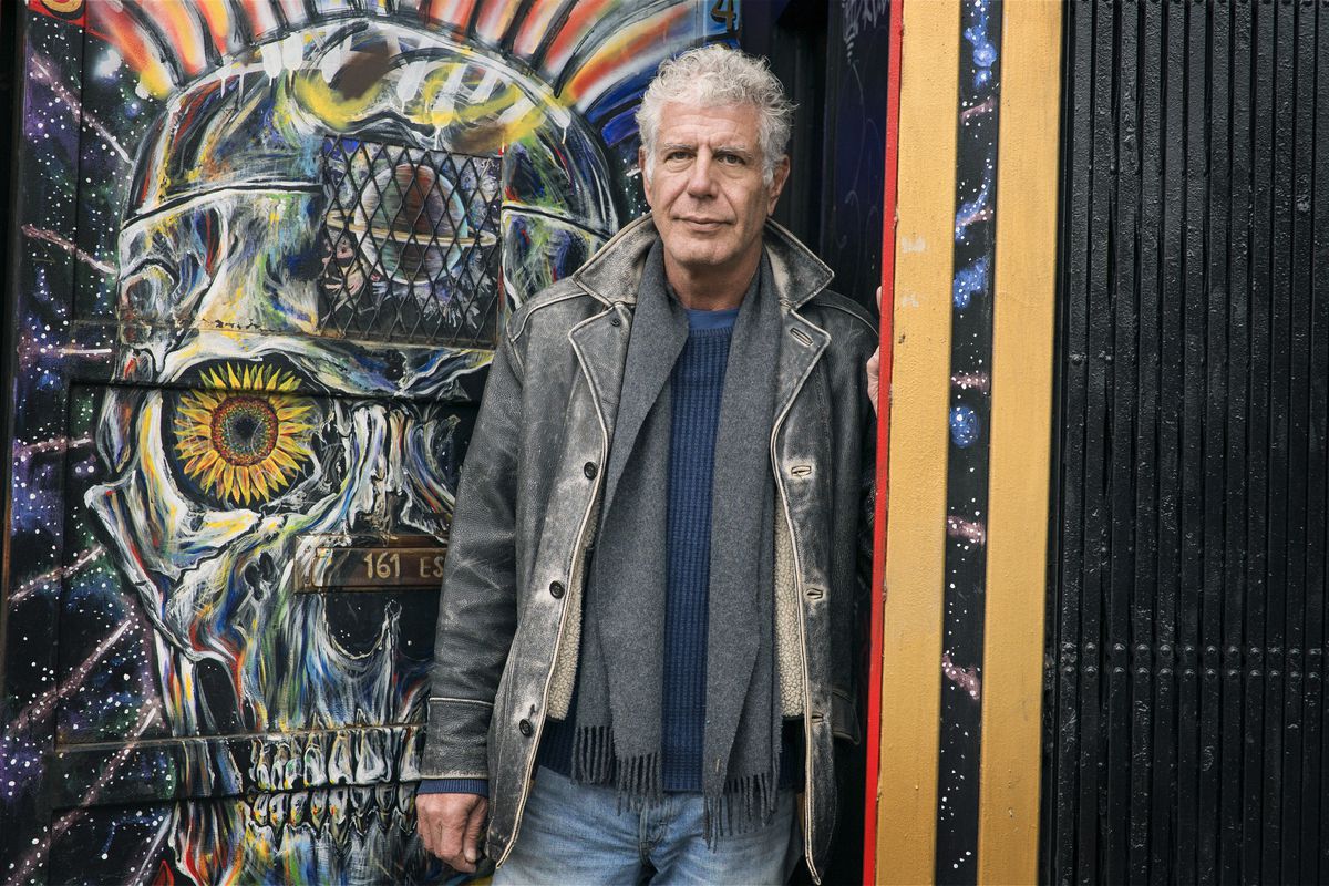 Anthony Bourdain poses with street art outside Patterson’s Outlaw Art Gallery in the Lower East Side episode of Parts Unknown.