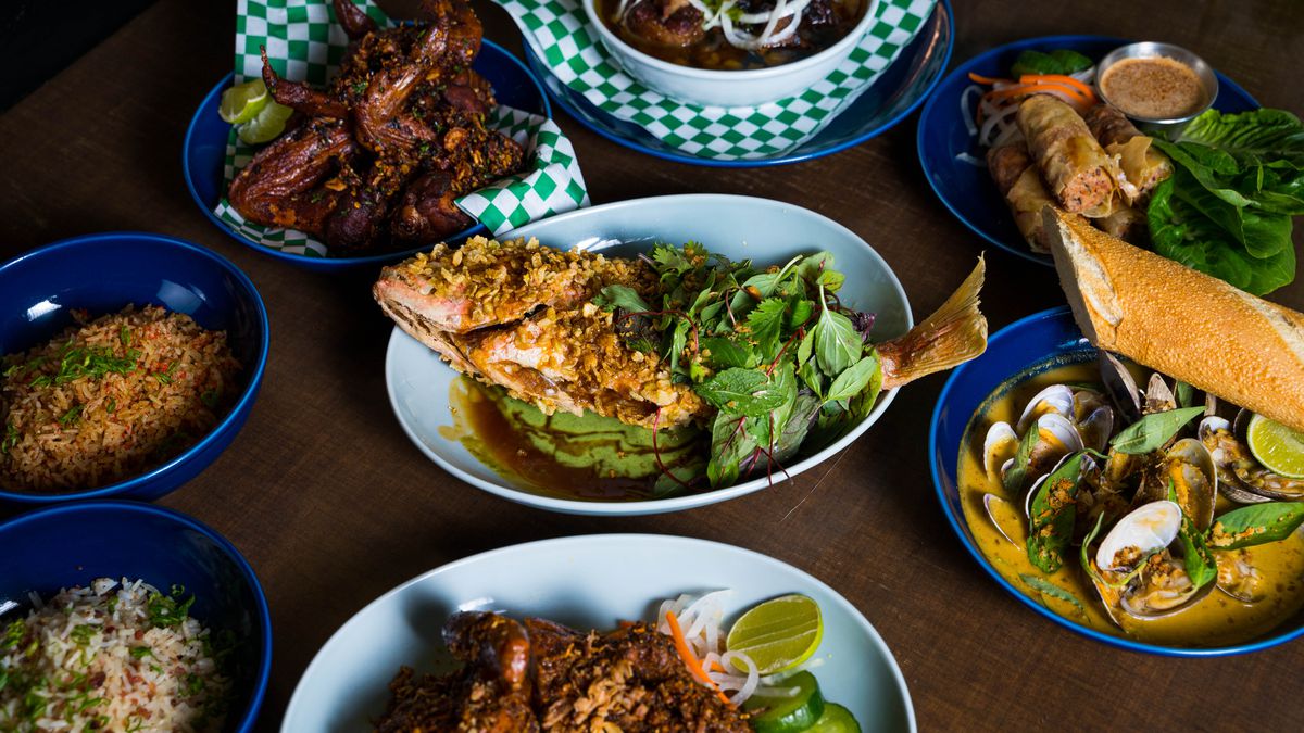An array of dishes — a whole fish, oxtail stew, and fried chicken wings — from All Day Baby’s new menu.