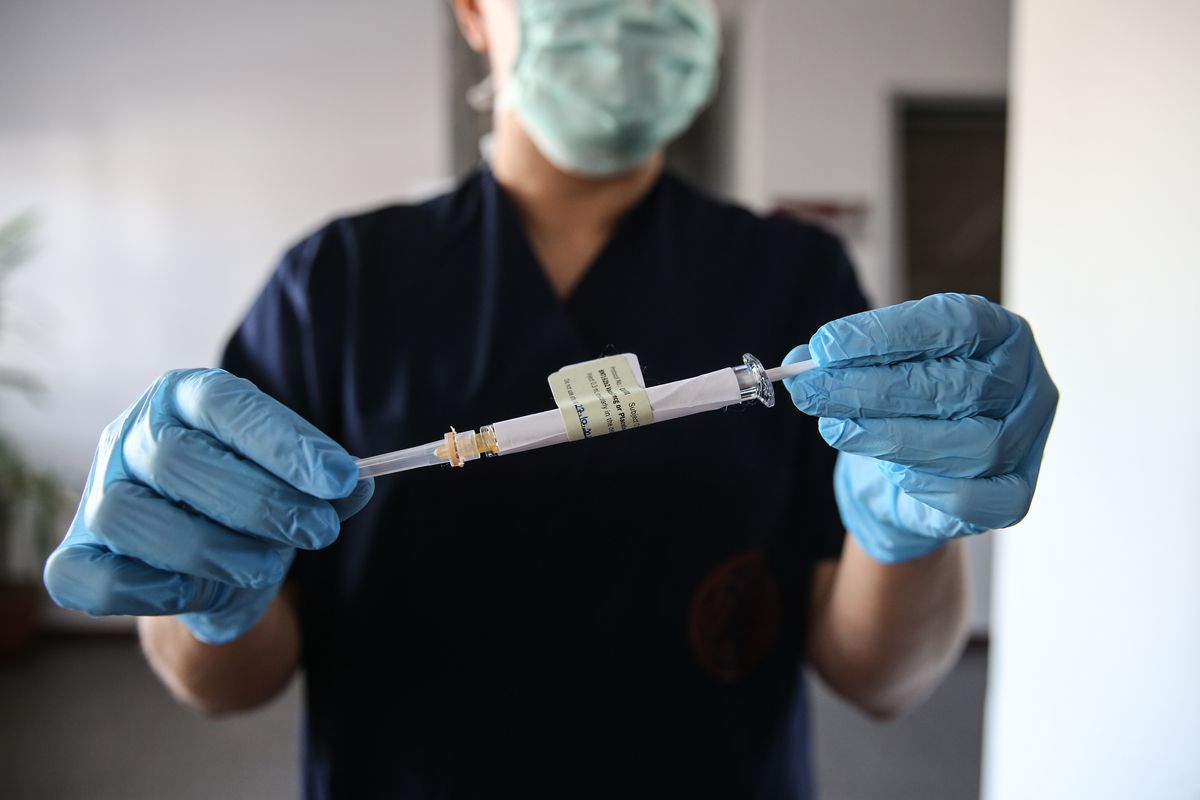 A health care worker holds an injection syringe of the phase 3 vaccine trial, developed against the novel coronavirus pandemic by Pfizer and German company BioNTech.