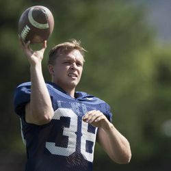 Kicker Vance "Moose" Bingham tosses the ball to a coach during a BYU football practice at BYU's practice fields Thursday, Aug. 14, 2014.