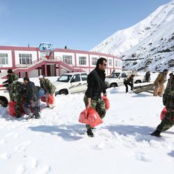 Afghans carry emergency food to deliver to people affected by an avalanche, in Panjshir province, north of Kabul, Afghanistan, Friday, Feb. 27, 2015. The death toll from severe weather that caused avalanches and flooding across much of Afghanistan has jumped to more than 200 people, and the number is expected to climb with cold weather and difficult conditions hampering rescue efforts, relief workers and U.N. officials said Friday. 