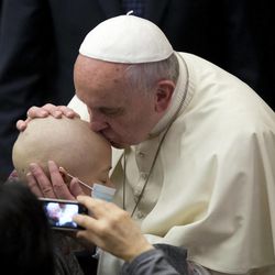 Pope Francis kisses a child during a special audience with participants of the 'World Congress of Accountants', in the Paul VI Hall at the Vatican, Friday, Nov. 14, 2014. 