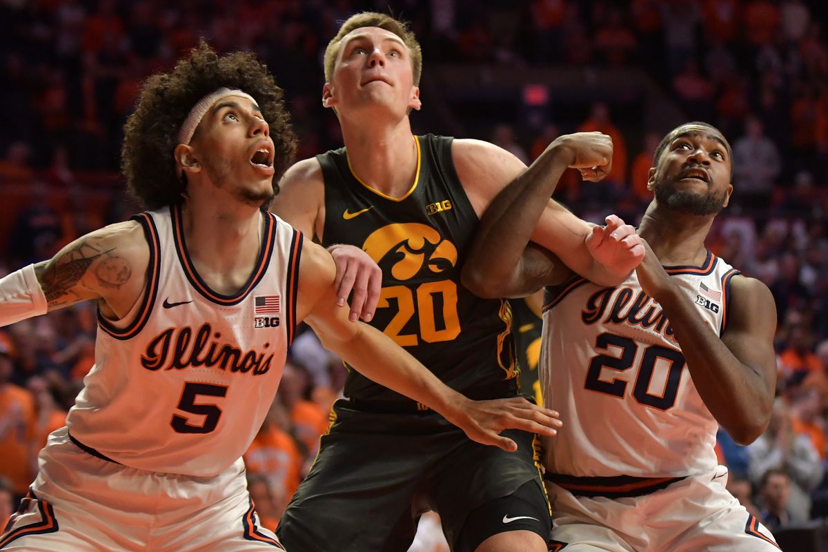 Illinois Fighting Illini guard Andre Curbelo and teammate fight for position under the basket with Iowa Hawkeyes guard Payton Sandfort during the second half at State Farm Center.